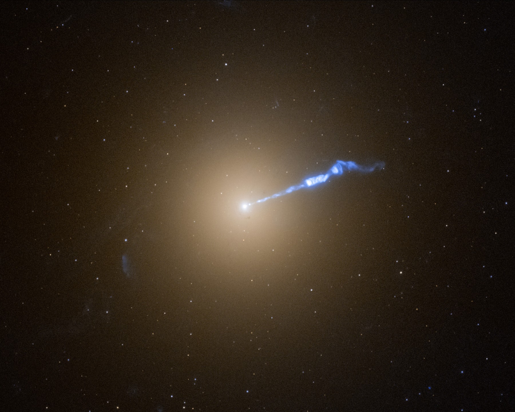 Hubble Space Telescope image of giant elliptical galaxy M87 with a 3,000-light-year plasma jet streaming from the central black hole.